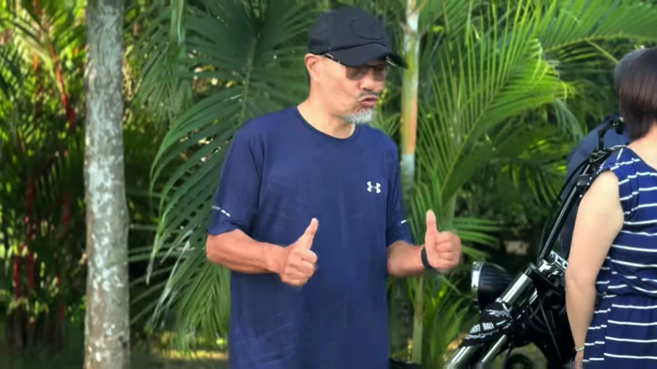 バイク横で両手サムズアップの男性メンバー｜2025年6月 バリ島ハーレーツーリング — TEAM THE GHOST West Bali