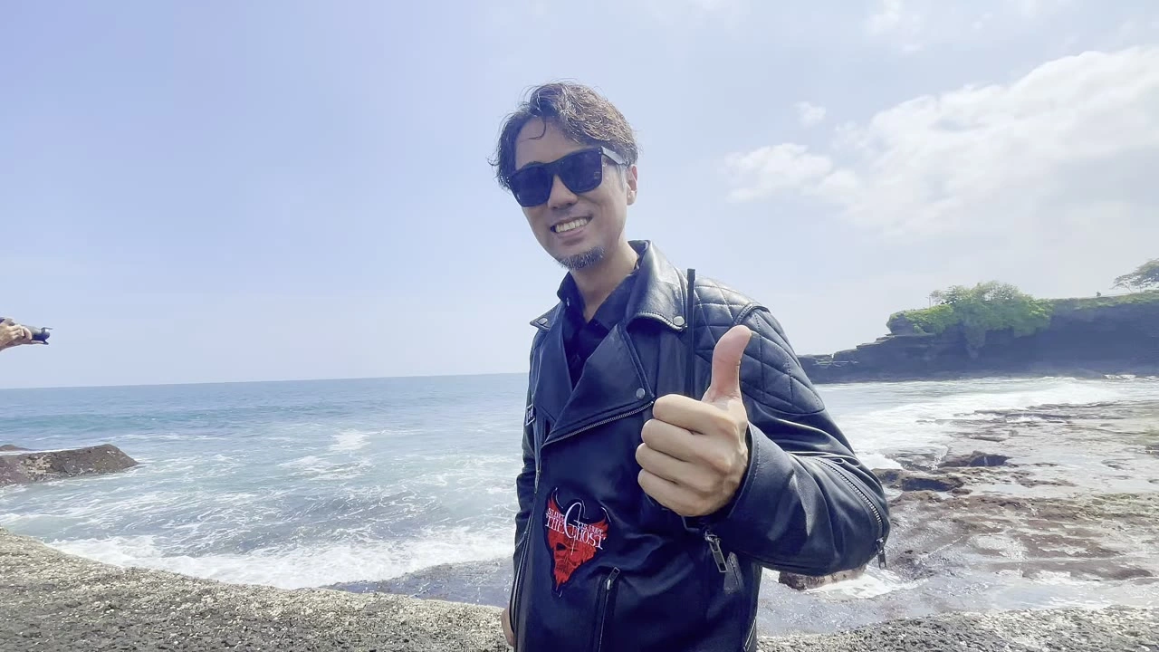 海辺でサムズアップするメンバー（顔ドアップ）｜2025年7月 バリ島ハーレーツーリング — TEAM THE GHOST West Bali