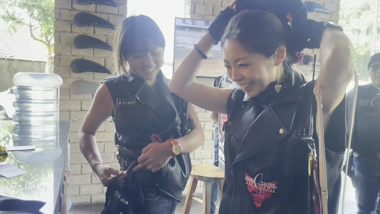 ベストを試着して微笑む女性｜2025年8月 バリ島ハーレーツーリング — TEAM THE GHOST West Bali