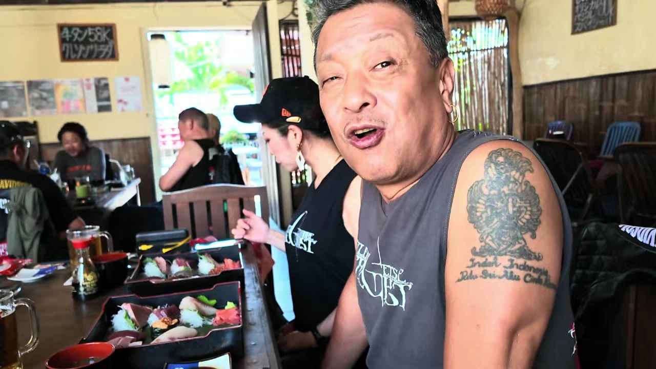 タトゥーの男性が丼を掲げて大口｜2025年10月 バリ島ハーレーツーリング — TEAM THE GHOST West Bali