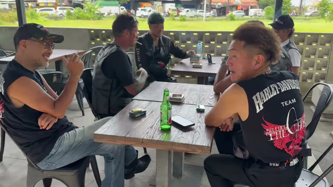 カフェのテーブルでキャップの男性が語る｜2025年11月 バリ島ハーレーツーリング — TEAM THE GHOST West Bali