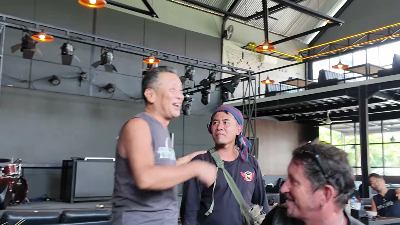 カフェでタンクトップの男性が大笑い｜2025年11月 バリ島ハーレーツーリング — TEAM THE GHOST West Bali