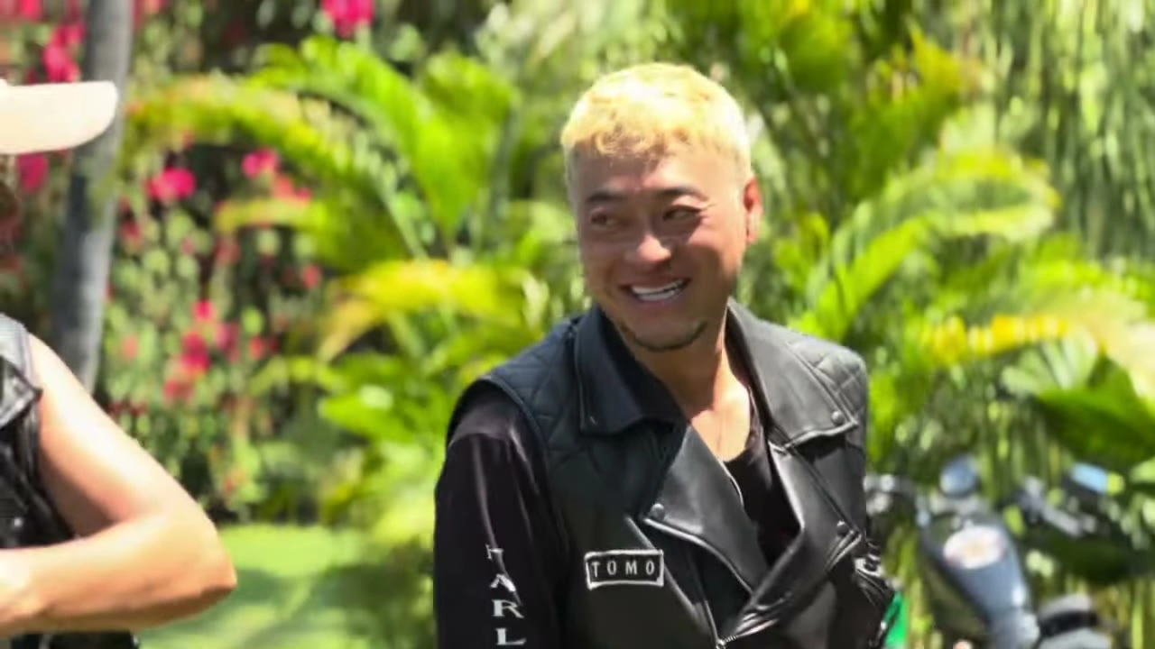 金髪の男性が革ジャンで花の前で笑顔｜2025年11月 バリ島ハーレーツーリング — TEAM THE GHOST West Bali