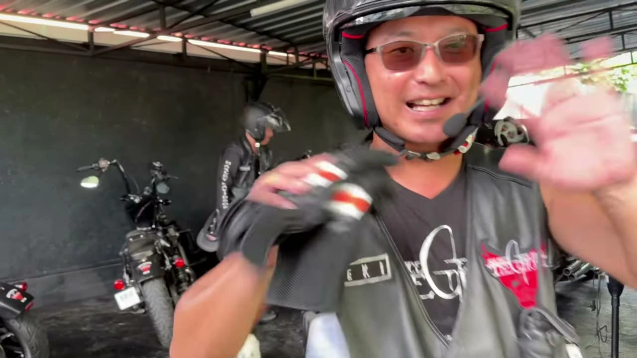 オープンフェイスの男性がカメラに手を振り笑顔｜2025年11月 バリ島ハーレーツーリング — TEAM THE GHOST West Bali