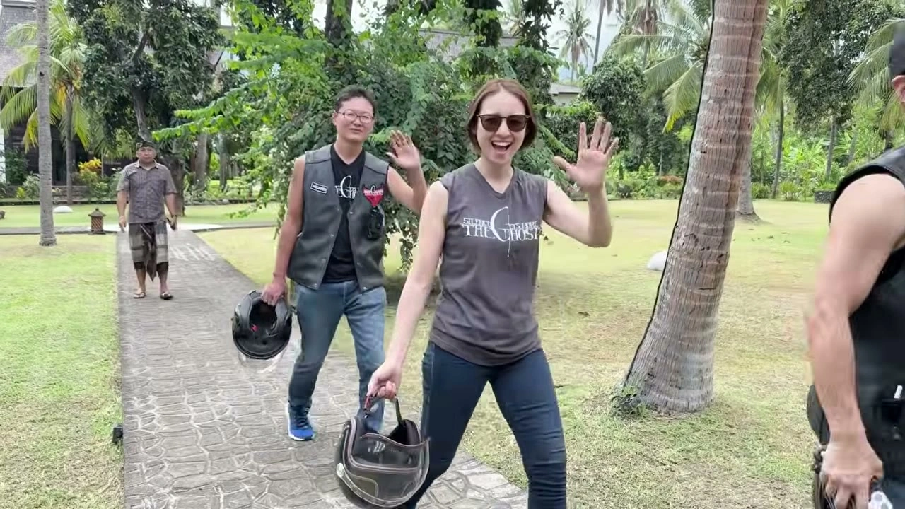女性が満面の笑みで手を振り歩く｜2025年11月 バリ島ハーレーツーリング — TEAM THE GHOST West Bali