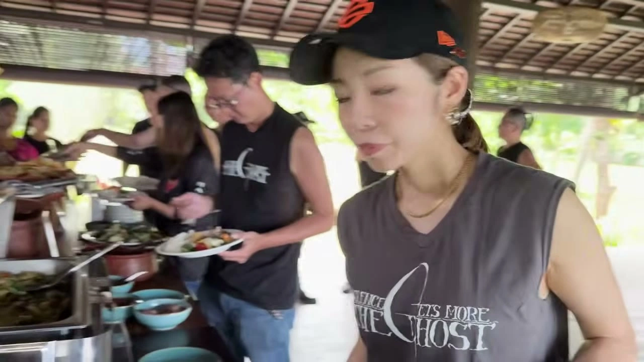 キャップとベストの女性が食事｜2025年11月 バリ島ハーレーツーリング — TEAM THE GHOST West Bali