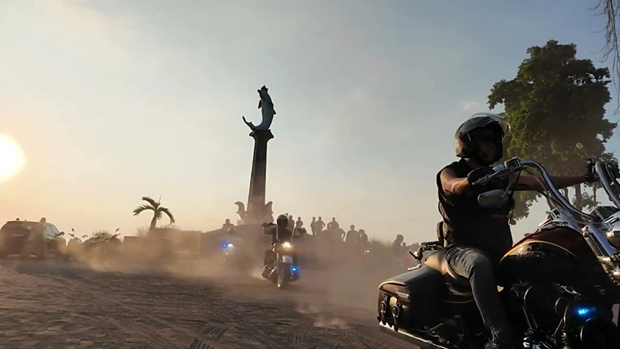 夕景のモニュメント前を砂埃あげて走る｜2026年6月 バリ島ハーレーツーリング — TEAM THE GHOST West Bali