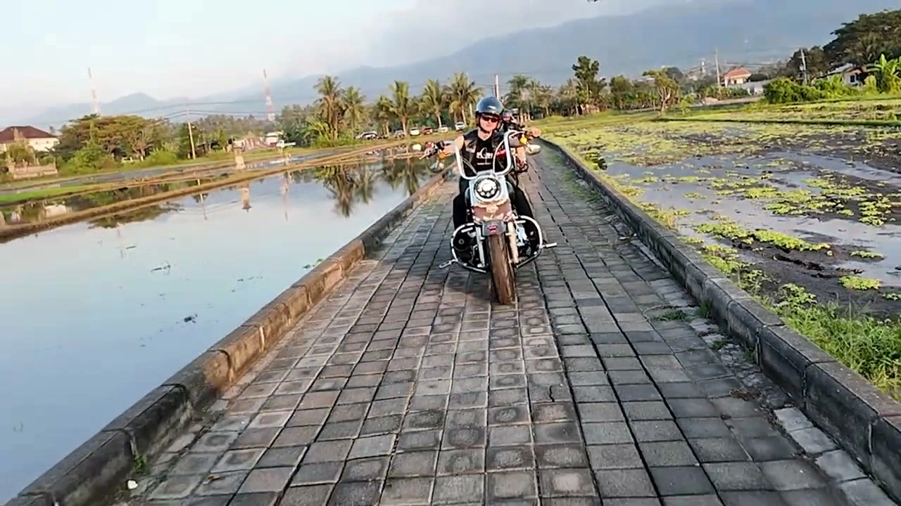 田んぼの一本道をバイクが来る（夕景）｜2026年6月 バリ島ハーレーツーリング — TEAM THE GHOST West Bali