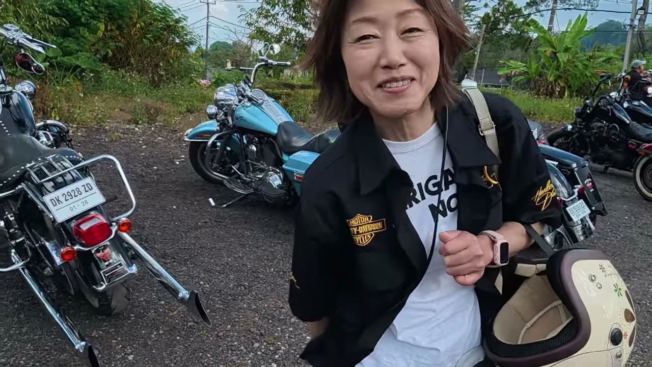 休憩地でヘルメットを抱えて微笑む女性メンバー｜2026年8月 バリ島ハーレーツーリング — TEAM THE GHOST West Bali
