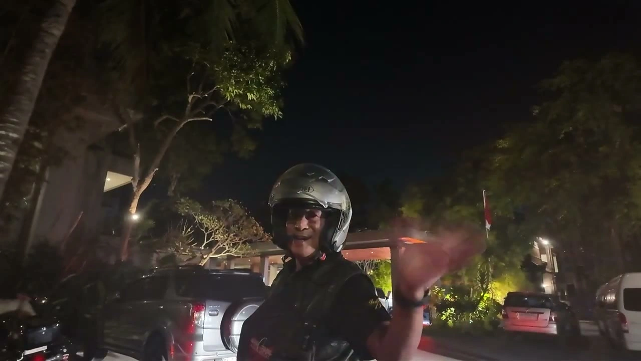 夜、宿に到着。ヘルメット姿で手を振る｜2026年9月 バリ島ハーレーツーリング — TEAM THE GHOST West Bali