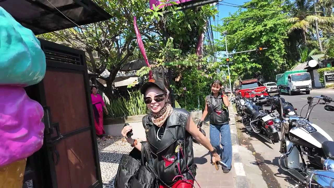 アイスクリームの看板の前、笑顔で歩くメンバー｜2026年9月 バリ島ハーレーツーリング — TEAM THE GHOST West Bali