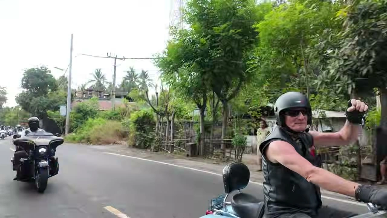 拳を突き上げて走る仲間｜2026年9月 バリ島ハーレーツーリング — TEAM THE GHOST West Bali