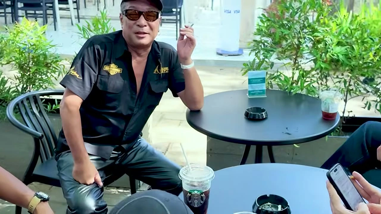 サングラス姿で、テラス席からカメラに笑いかける｜2026年10月 バリ島ハーレーツーリング — TEAM THE GHOST West Bali