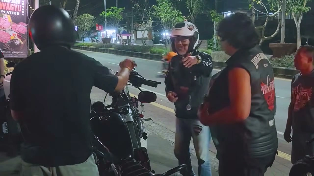 夜の通りで、ヘルメット姿の仲間を出迎える｜2026年10月 バリ島ハーレーツーリング — TEAM THE GHOST West Bali